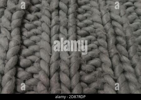 Detail of a rustic handmade chunky rug. Knitted wool background. Stock Photo