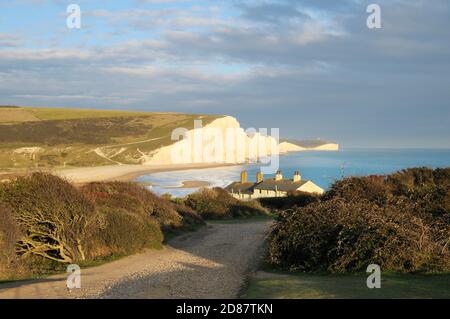Seven Sisters cliffs and coastguard cottages with Belle Tout Lighthouse in distance, Seaford Head, South Downs National Park, East Sussex, England, UK