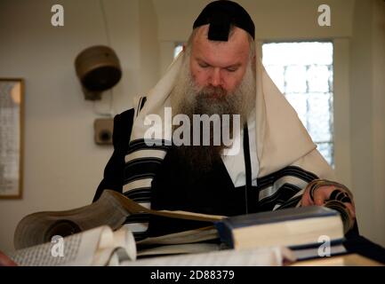 Rabbi reading from the Book of Esther in the Synagogue during Purim Stock Photo