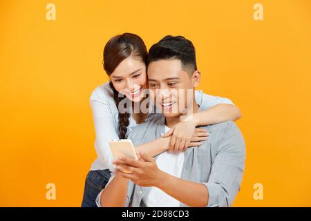 Couple or friends laughing funny and having fun with a smart phone Stock Photo