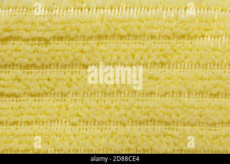 Fabric yellow striped background. Soft fiber texture of interlaced polyester close-up. fine grain fabric. Stock Photo