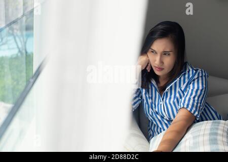 Girl with anxiety and sadness looks out the window of the train car ...