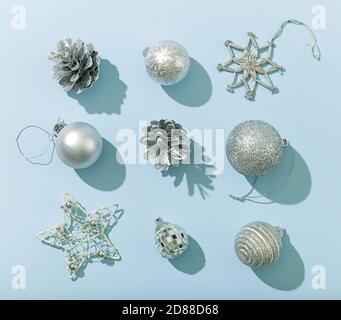 various silver color christmas decorations on blue paper background, flat lay, top view Stock Photo