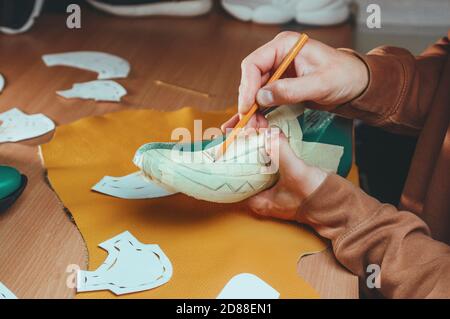 Shoemaker drawing a pattern on the shoe model Stock Photo