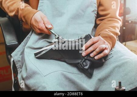 Shoemakers hands making shoe using special tools Stock Photo