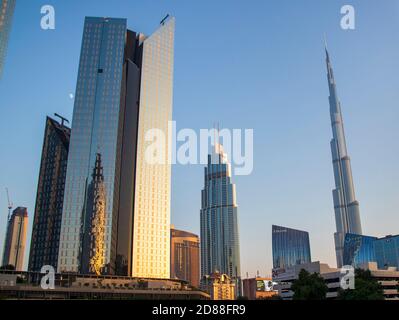 Towers in Dubai International Financial Center, Burj Khalifa, Tallest building in the world can be seen in the scene. Outdoors Stock Photo