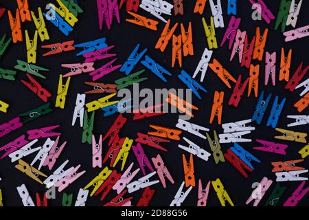 multicolor wooden pins on black background, colorful banner for text Stock Photo