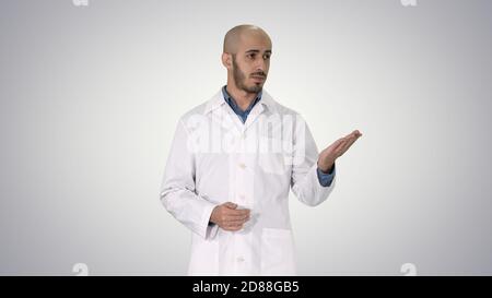 Arab doctor man in medical coat talking and presenting with hand Stock Photo