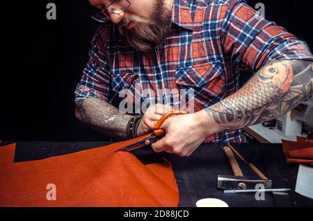 Artisan working with leather wording with leather goods in leather studio Stock Photo