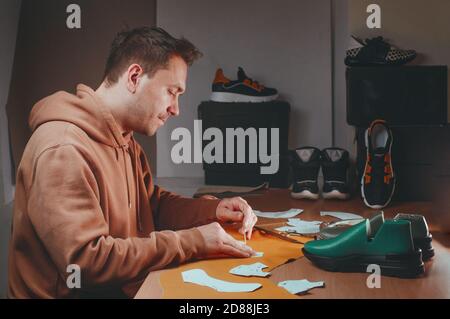 Shoemaker drawing a pattern on the shoe model Stock Photo