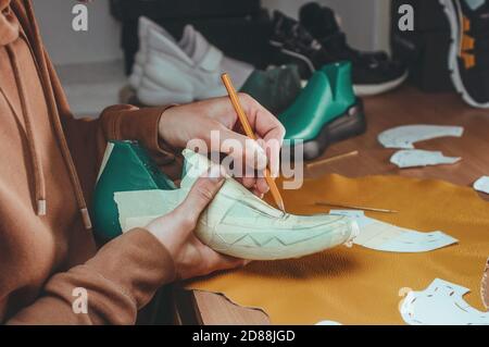 Shoemaker drawing a pattern on the shoe model Stock Photo