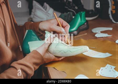 Shoemakers hands making shoe using special tools Stock Photo