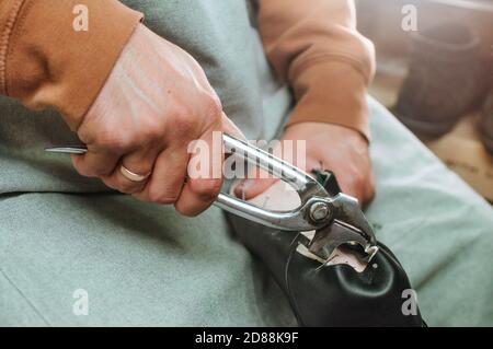 Shoemakers hands making shoe using special tools Stock Photo