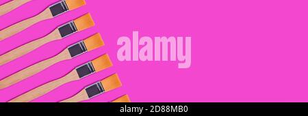 Creative banner with paint brushes arrangement on a magenta background. Artistic composition with place for text. Stock Photo