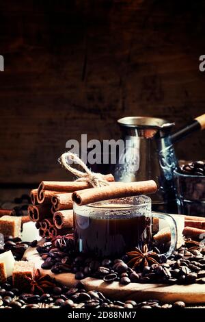 Espresso, coffee maker, spilled coffee beans, spices, sugar, vintage wooden background, selective focus Stock Photo