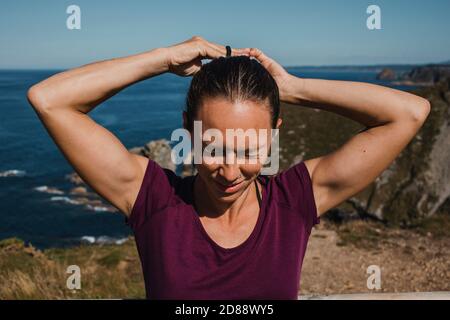 Premium Photo  Athletic young woman in sports dress laughing and making  ponytail while looking at the ocean