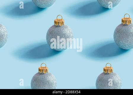 Christmas seamless pattern from blue shiny balls on a pastel blue background with shadows, copy space. Congratulation card. Stock Photo