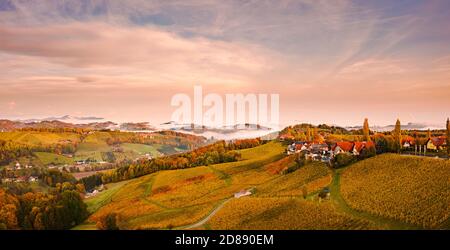 Aerial view from Eckberg at Autumn grape hills and foggy Alps in distance. Stock Photo