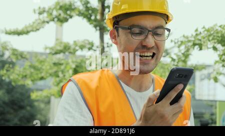 Angry construction worker screaming on the phone. Stock Photo