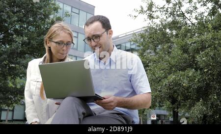 Surfing the net together. Business colleagues sitting on the ben Stock Photo