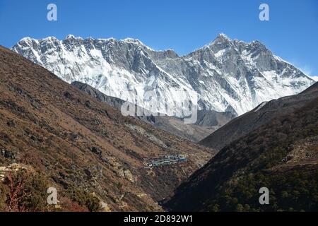 The enormous wall between Nuptse and Lhotse dwarfs the village of Shomare. Stock Photo