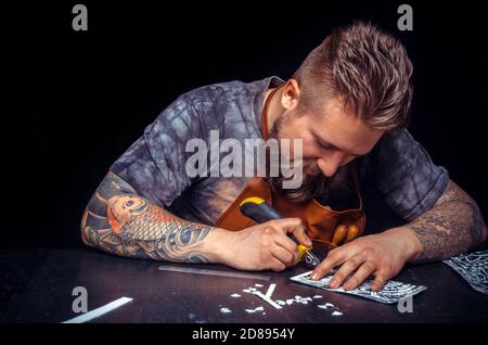 Leather Artist produces leather goods at workshop Stock Photo