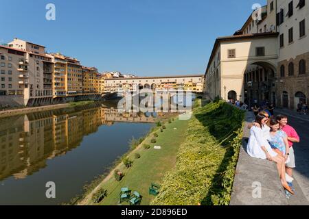 Tourists make photos of Ponte Vecchio across Arno river in Florence, Italy Stock Photo