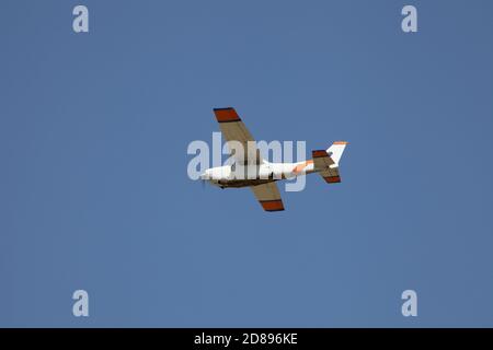 Small hite plane flies in the sky. Takeoff and landing. Arrival and departure. Place for your text. Little lane isolated on blue background. Smart Stock Photo
