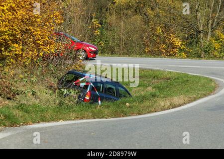 The car in the ditch by the road after the traffic accident. Abandoned and waiting for tow. Stock Photo