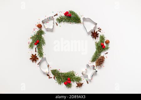 Christmas wreath made from molds for cookies, spices and a Christmas tree on a white background with copy space Stock Photo