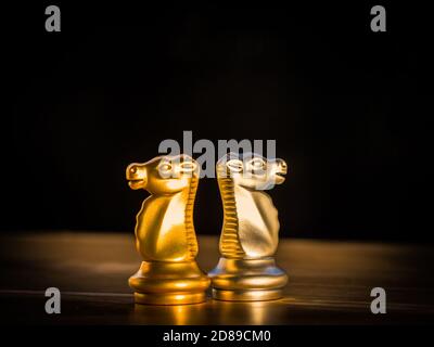 Gold knight chess turn back silver knight chess on chess board for business partner or collaboration. Business ideas and competition and strategy idea Stock Photo