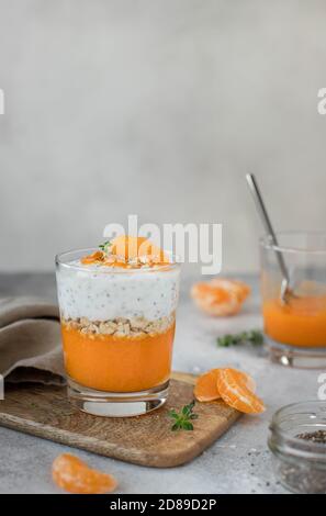 healthy chia pudding with mandarin in a glass. light gray background. Stock Photo