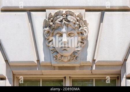 A carved woman's face decorates the keystone above a window on the EPA's William Jefferson Clinton Federal Building on Constitution Avenue in DC Stock Photo