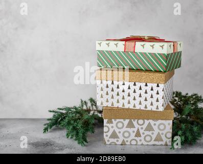 Christmas decorations with various colorful gift boxes, Christmas tree branches. gray background, copy space Stock Photo