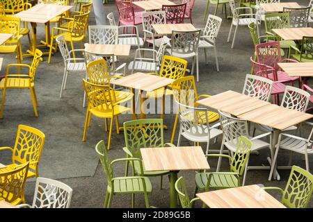 Empty chairs and tables in an outdoor dining area at the Eden Project in Cornwall Stock Photo