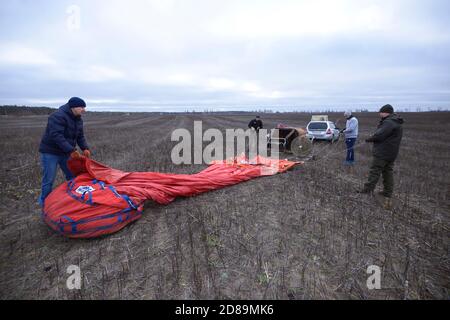 Men prepare hot-air red balloon for launching, car and trailer with equipment set on a background Stock Photo