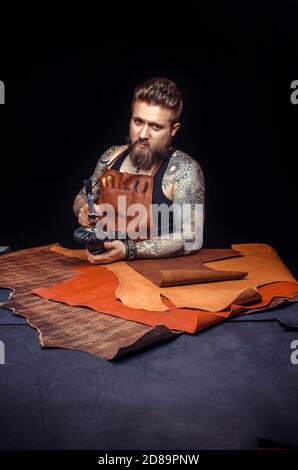 Handyman processing a leather workpiece at the tanning shop Stock Photo