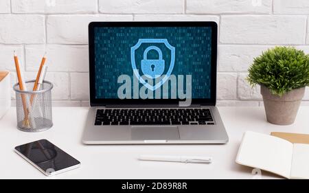 Laptop on table with padlock icon on the screen Stock Photo