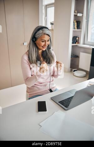 Adult beautiful female sign language tutor participating in online training from school office Stock Photo