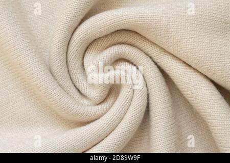 Background of woolen knit beige warm sweater top view Stock Photo