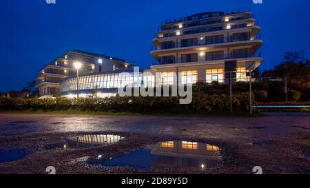 Ahrenshoop, Germany. 21st Oct, 2020. The windows of the wellness hotel The Grand on the Fischland-Darss-Zingst peninsula are reflected in a puddle. The hotel is located only a few metres from the beach. From the roof terrace tourists have a fantastic view of the Baltic Sea. Credit: Stephan Schulz/dpa-Zentralbild/ZB/dpa/Alamy Live News Stock Photo