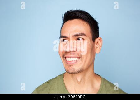 Close up portrait of smiling older asian man on blue background Stock Photo