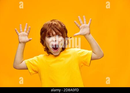 Expressive red-haired boy shows his palms to the camera Copy space Stock Photo