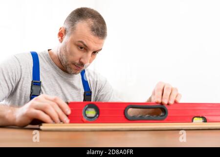 Carpenter Using Carpentry Level Tool Making Shelf Indoors Stock Photo