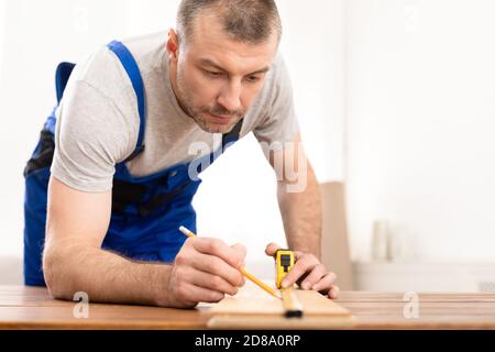Craftsman Working With Wooden Board Making Furniture In His Studio Stock Photo
