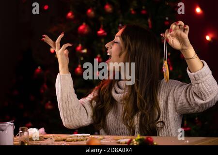 Joyful attractive woman singing xmas songs while cooking Christmas bakery Stock Photo