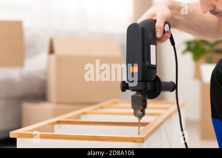 Unrecognizable Furniture Assembler Assembling Cabinet Shelf Working Using Drill Indoors Stock Photo