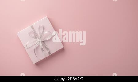 Festive box on pastel pink background. Flat lay . Copy space Stock Photo
