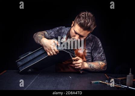 Leather man cutting out leather goods Stock Photo