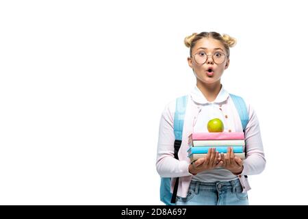 Shocked schoolgirl holding apple and books isolated on white Stock Photo